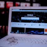 Laptop on a desk showing the Pexels homepage, highlighting its web interface.